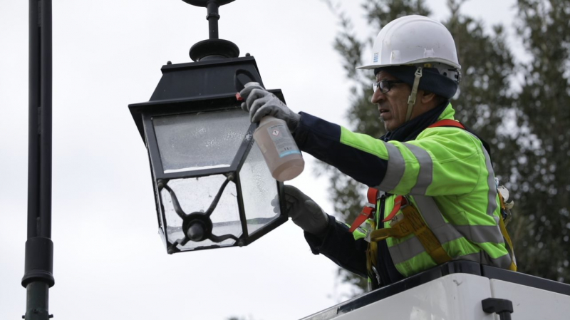 Electricien effectuant maintenance éclairage public avec EPI spécifiques