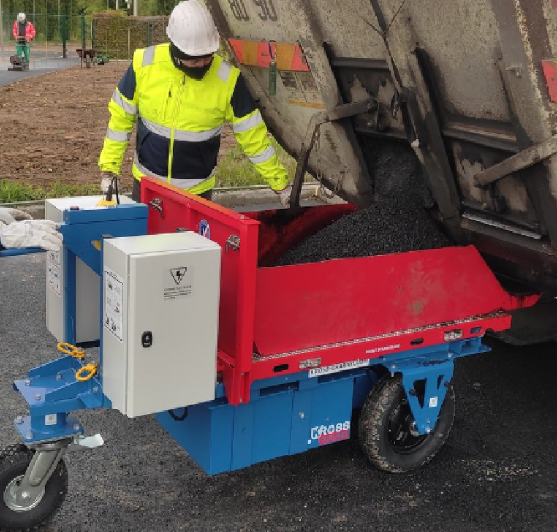 Opérateur en train de verser de l'enrobé dans un chariot de manutention électrique Kross Builder 500